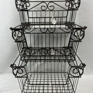 May include: A three-tiered storage unit constructed from black metal wire. Each of the three rectangular baskets features a grid-patterned base and sides, accented with decorative scrollwork at the top corners and along the upper edges.