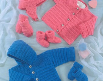 May include: A set of two knitted baby outfits, one in bright pink and one in royal blue. Each set includes a long-sleeved cardigan with heart-shaped buttons, a pair of booties, and a matching hat or hood. The garments feature a ribbed texture.