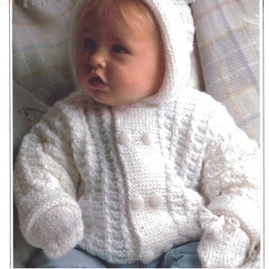 May include: A white knitted hooded jacket featuring a textured pattern and a double-breasted front closure with four round white buttons. The garment includes long sleeves with matching white knitted mittens attached at the cuffs, providing a cohesive look.