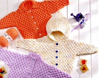 Puede incluir: Tres cárdigans tejidos a mano con un patrón texturizado de tejido de cesta. Uno es naranja brillante con botones blancos, uno es blanco con motas amarillas y moradas y capucha con botones azules, y uno es morado claro con botones a juego.