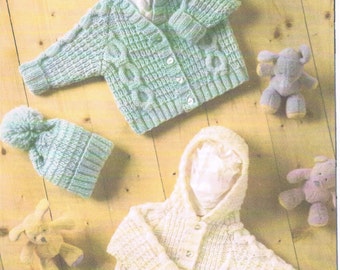 May include: A light green cable-knit cardigan with buttons, a matching pom-pom beanie, and a cream-colored hooded cable-knit cardigan with buttons, accompanied by three small plush animal toys in yellow, purple, and light blue colors.
