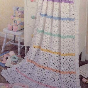 May include: A white crocheted blanket featuring horizontal stripes in pastel shades of purple, blue, mint green, yellow, peach, and pink. The blanket has a ruffled white border along the edges and a delicate, openwork diamond stitch pattern throughout.