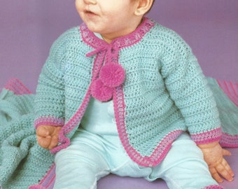 May include: A light blue crochet cardigan featuring a vibrant pink trim along the edges, long sleeves, and two decorative pink pom-poms at the neckline. The garment is paired with matching light blue crochet booties with pink trim and pom-poms.