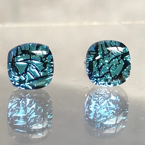 Puede incluir: Un par de pendientes cuadrados con un diseño de vidrio craquelado azul y negro.