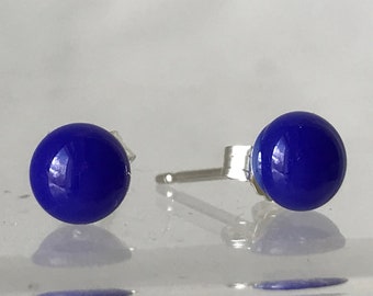 May include: A pair of blue glass stud earrings with silver posts.