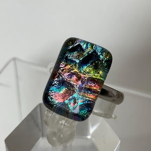 Anel ajustável em prata de lei com pedra de vidro dicróico retangular multicolorida em arco-íris.