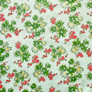 May include: A light green fabric with a repeating pattern of green, red, and yellow floral bouquets.
