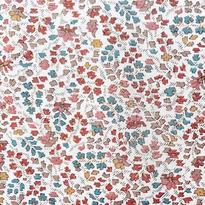 May include: A white fabric with a repeating pattern of small, colourful flowers. The flowers are in shades of red, blue, and yellow.