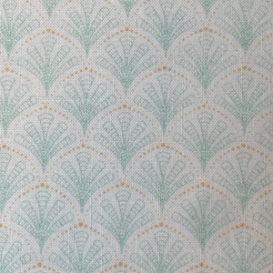 May include: A white fabric with a repeating pattern of green and gold fan shapes. The fabric has a textured woven look.