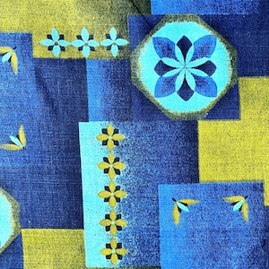 May include: A blue and green geometric fabric with a repeating pattern of flowers and leaves. The fabric has a textured surface.