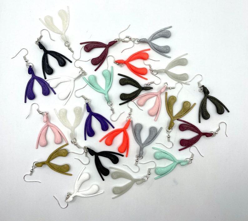 May include: A collection of 18 pairs of earrings, each featuring a unique anatomical design. The earrings are made of a variety of colors, including pink, orange, purple, green, gold, and gray. The earrings are all made of a smooth, shiny material.