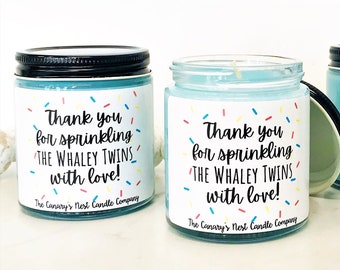 May include: Four blue glass candle jars with black lids and white labels. The labels have colorful sprinkles and the text "Thank you for sprinkling The Whaley Twins with love! The Canary's Nest Candle Company."