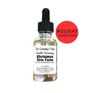 May include: A clear glass bottle with a black dropper top, labeled "Christmas Tree Farm" car air freshener refill. The label also includes "The Canary's Nest Candle Company" and "Holiday Collection" in a red circle. The bottle contains 1 oz of refill oil.