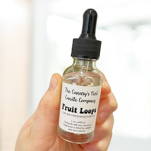 May include: A clear glass bottle with a black dropper top, labeled "Fruit Loops" car air freshener refill. The label also reads "The Canary's Nest Candle Company." The bottle contains 1 oz. of refill oil.