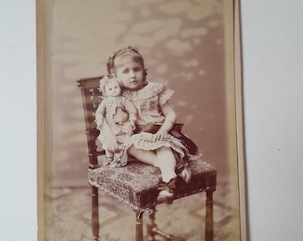 Late 19th century, Authentic film photography, portrait of a child with her doll, old photograph wall decoration