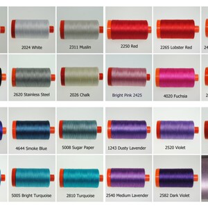 May include: A collection of 18 spools of thread in various colors, including natural white, black, red, pink, blue, teal, purple, and lavender. Each spool is labeled with a number and a color name.