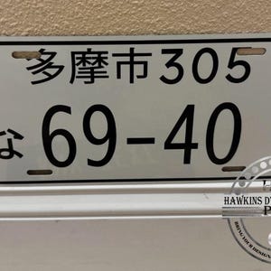 May include: A rectangular license plate with Japanese characters and the numbers "305" and "69-40" in black. The plate has a white background and is mounted on a wall. The text "HDSP HAWKINS DYE SUBLIMATION PRODUCTS" is visible at the bottom.