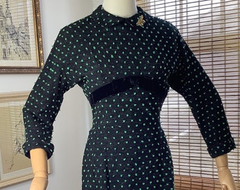 Vintage 1950s wool wiggle dress, black flecked with green textured dots with pockets and velvet bow