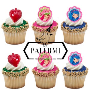 May include: Six decorated cupcakes with different toppers. The toppers feature a strawberry shortcake character, a strawberry, and a blue-haired character. The cupcakes are decorated with sprinkles and frosting.