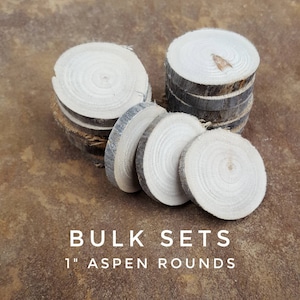 May include: A bulk set of 1-inch aspen wood rounds. The rounds are natural in color and have a smooth, polished finish. They are stacked in a pile on a brown surface.