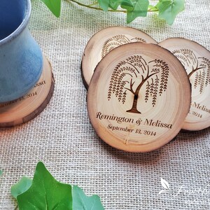 May include: Four wooden coasters with a laser-etched design of a weeping willow tree. The coasters are personalized with the names "Remington & Melissa" and the date "September 13, 2014".