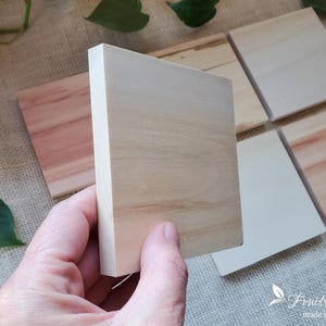 May include: Four wooden squares of different sizes and colors. The squares are made of natural wood and have a smooth finish. The squares are arranged in a staggered pattern. The largest square is in the background and the smallest square is in the foreground.