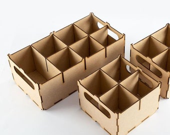Puede incluir: Dos cajas de almacenamiento de madera con divisores. La caja más grande tiene nueve compartimentos y la caja más pequeña tiene cuatro compartimentos.