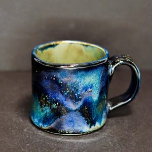 May include: A set of three ceramic nesting bowls in shades of blue, green, and white. The bowls feature a speckled glaze and a simple, modern design. The largest bowl is approximately 7 inches in diameter.