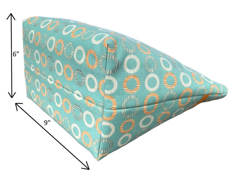 May include: A turquoise tote bag with a white and orange circle pattern. The bag measures 9 inches wide and 6 inches tall.