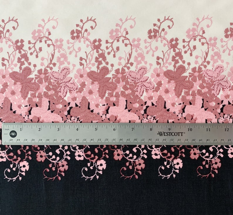 May include: A white fabric with a pink and red floral pattern. The pattern is a gradient, with the pink flowers fading to red at the bottom. The fabric is measured with a ruler, showing 12 inches.