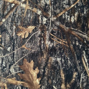 Pode incluir: Tecido camuflado com uma mistura de tons castanhos, cinzentos e pretos. O design incorpora galhos de árvores e folhas caídas, criando uma estética natural de floresta. Ideal para roupas e acessórios de exterior.