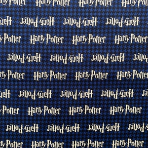 May include: Blue and black fabric with a repeated pattern of the words "Harry Potter" and "Jallod GueH" in white.