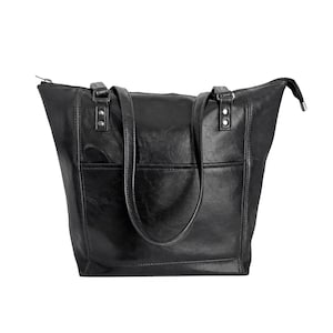 May include: A black tote bag with a smooth, slightly glossy finish, featuring two shoulder straps attached with silver-toned metal rivets, a horizontal front pocket, and a top zipper closure that extends slightly beyond the bag's main body.