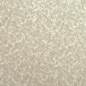 May include: Cream-colored fabric with a repeating pattern of delicate, light brown leaves and tiny dots. The leaves are arranged in a flowing, organic design, creating a subtle, textured appearance. This fabric is suitable for various sewing and crafting projects.
