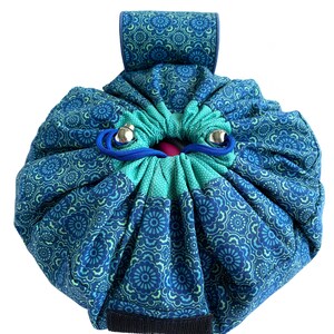 May include: A blue and green drawstring bag with a floral pattern. The bag has a handle and a zipper closure.