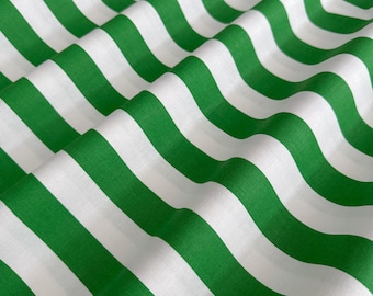 Puede incluir: Primer plano de una tela con un patrón repetitivo de rayas diagonales anchas. Las rayas alternan entre un verde brillante y blanco. La tela está ligeramente arrugada, creando una sensación de profundidad y textura.