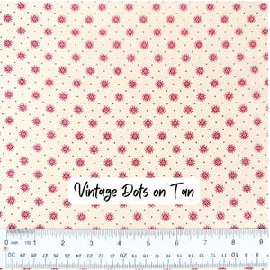 Op de afbeelding: Cr&egrave;mekleurige stof met een herhalend patroon van kleine, donkerrode bloemmotieven en stippen. De tekst "Vintage Dots on Tan" staat op de stof. Onderaan de afbeelding staat een liniaal.
