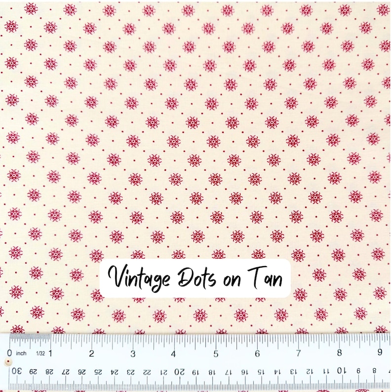 Op de afbeelding: Cr&egrave;mekleurige stof met een herhalend patroon van kleine, donkerrode bloemmotieven en stippen. De tekst "Vintage Dots on Tan" staat op de stof. Onderaan de afbeelding staat een liniaal.