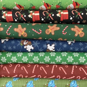 May include: Stack of six different Christmas fabric scraps. The fabrics feature various holiday designs, including candy canes, gingerbread men, snowmen, snowflakes, and bells.