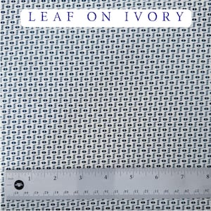 May include: Ivory fabric with a repeating pattern of dark blue leaf-like shapes. The text "LEAF ON IVORY" is displayed in a white rectangle at the top. A ruler is at the bottom, showing measurements in inches.