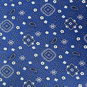 Puede incluir: Una tela de bandana azul con un patrón paisley blanco. El patrón incluye pequeños diamantes, formas de paisley y diseños florales.