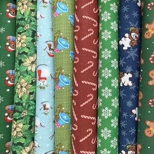 May include: A collection of eight different Christmas fabric scraps featuring various holiday themes, including snowmen, candy canes, bells, and snowflakes. The fabrics are in a variety of colors, including red, green, blue, and white.