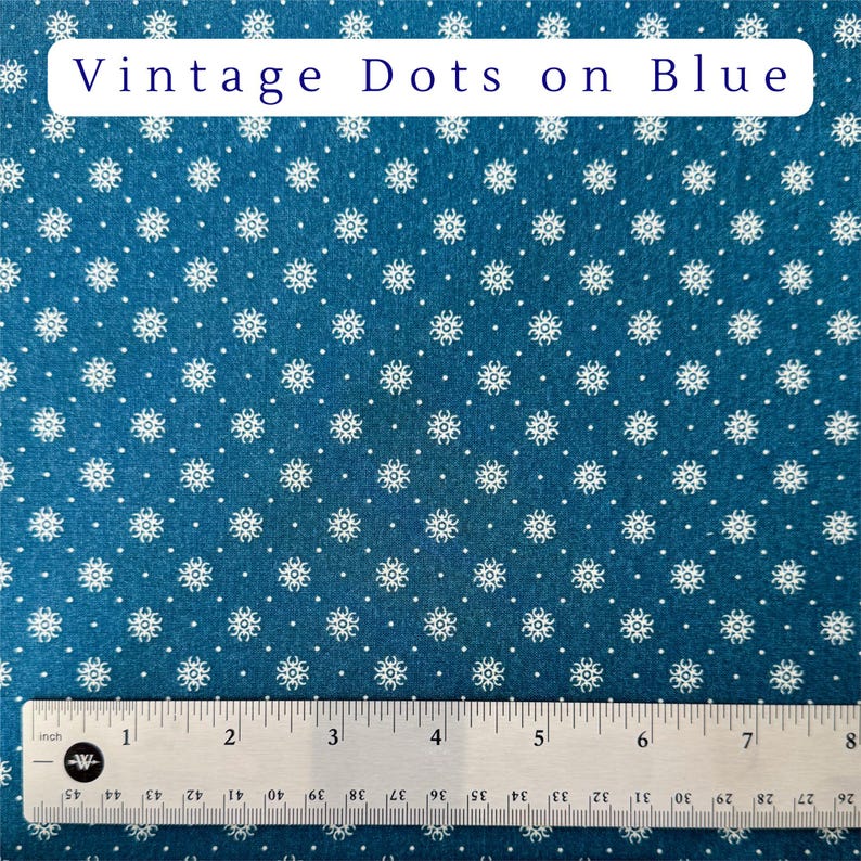 May include: Blue fabric with a repeating pattern of white floral shapes and dots. The text "Vintage Dots on Blue" is displayed at the top. A ruler is at the bottom, marked in inches.