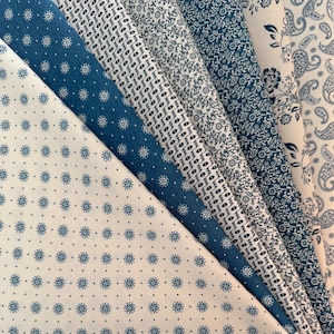May include: An assortment of blue and white patterned fabric swatches. The fabrics display various designs, including floral, dotted, and paisley patterns. The color palette is primarily blue and white, with a mix of light and dark shades of blue.