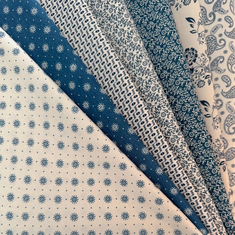 May include: An assortment of blue and white patterned fabric swatches. The fabrics display various designs, including floral, dotted, and paisley patterns. The color palette is primarily blue and white, with a mix of light and dark shades of blue.
