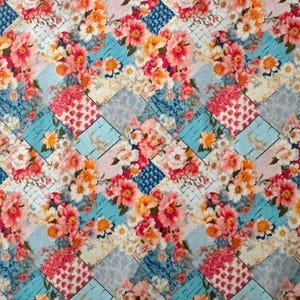 Puede incluir: Una colorida tela floral con un diseño de patchwork. El patrón presenta ramos de flores rosas, naranjas y blancas sobre un fondo de formas geométricas azules, rosas y blancas. La tela tiene una estética vintage y cottagecore.