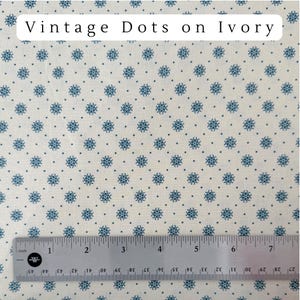 May include: Ivory fabric with a repeating pattern of small blue floral designs and dots. The text "Vintage Dots on Ivory" is at the top. A ruler with inch measurements is at the bottom.