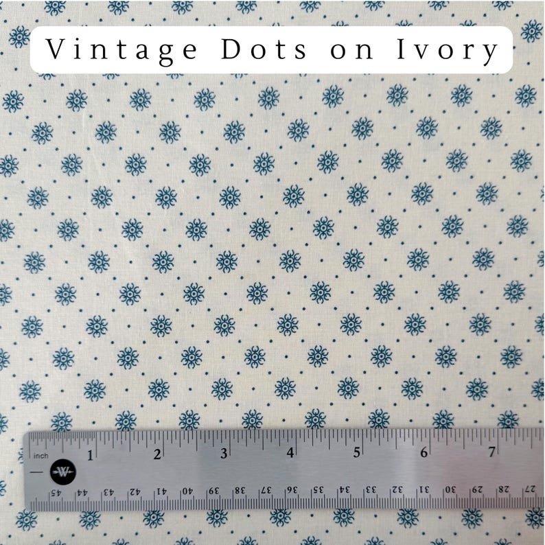 May include: Ivory fabric with a repeating pattern of small blue floral designs and dots. The text "Vintage Dots on Ivory" is at the top. A ruler with inch measurements is at the bottom.