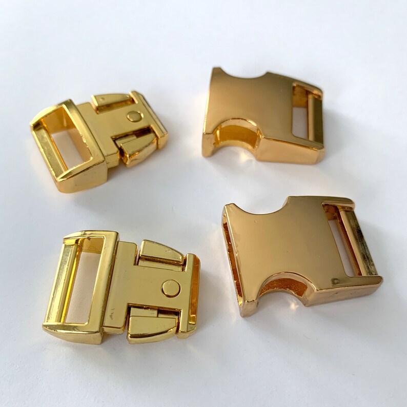 May include: Four gold-colored plastic side release buckles. The buckles are commonly used for dog collars, leashes, and other pet accessories.