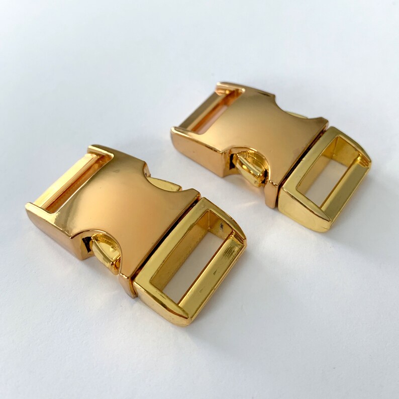 May include: Two gold-colored plastic side release buckles. The buckles are designed for use with straps or webbing.